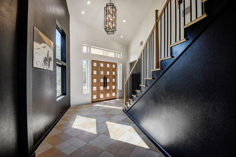 Entrance foyer featuring stairway, recessed lighting, tile patterned flooring, a chandelier, and a high ceiling Entrance foyer featuring stairway, recessed lighting, tile patterned flooring, a chandelier, and a high ceiling
