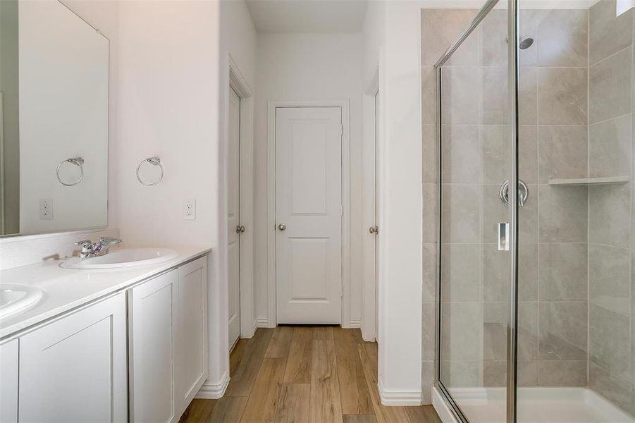 Bathroom featuring vanity, hardwood / wood-style flooring, and a shower with shower door