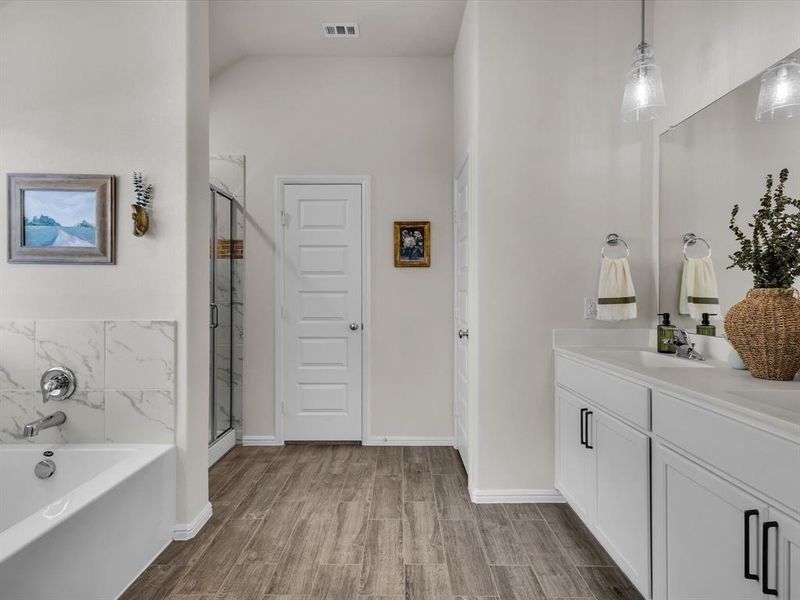 Generously sized
ensuite offers a tranquil experience, complete with dual sinks, garden tub, separate shower, and a large walk-in closet.