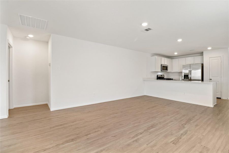 Spacious living area with wood-style flooring and a flexible layout Spacious living area with wood-style flooring and a flexible layout