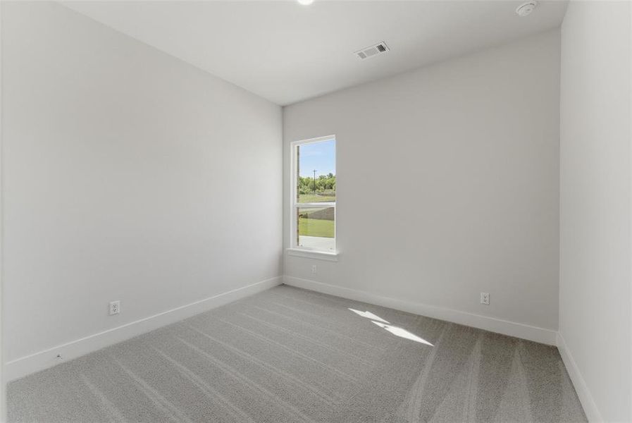 Unfurnished room featuring light carpet and baseboards