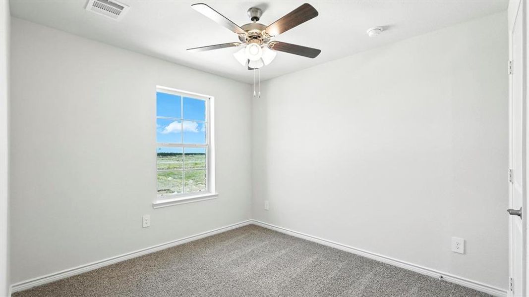 Room featuring light gray carpet, a window with a white frame, a ceiling fan with integrated lighting, and white walls