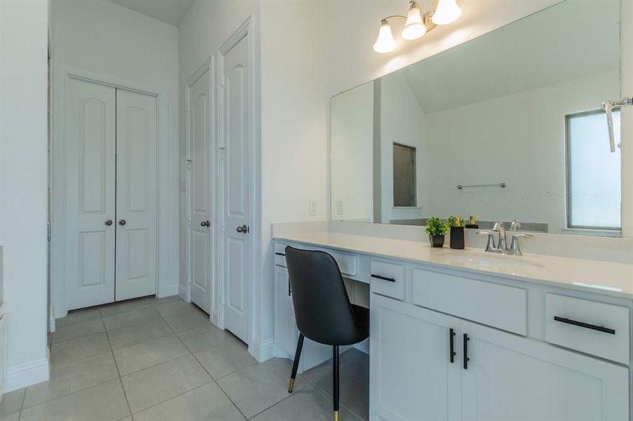 Vanity with a light-toned countertop, integrated sink, and chrome faucet