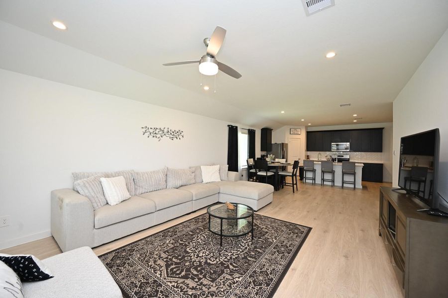 This spacious open-concept living area features a stylish kitchen with modern appliances and open to the dining area. It has beautiful flooring, recessed lighting, and a ceiling fan for a comfortable and inviting atmosphere. This spacious open-concept living area features a stylish kitchen with modern appliances and open to the dining area. It has beautiful flooring, recessed lighting, and a ceiling fan for a comfortable and inviting atmosphere.