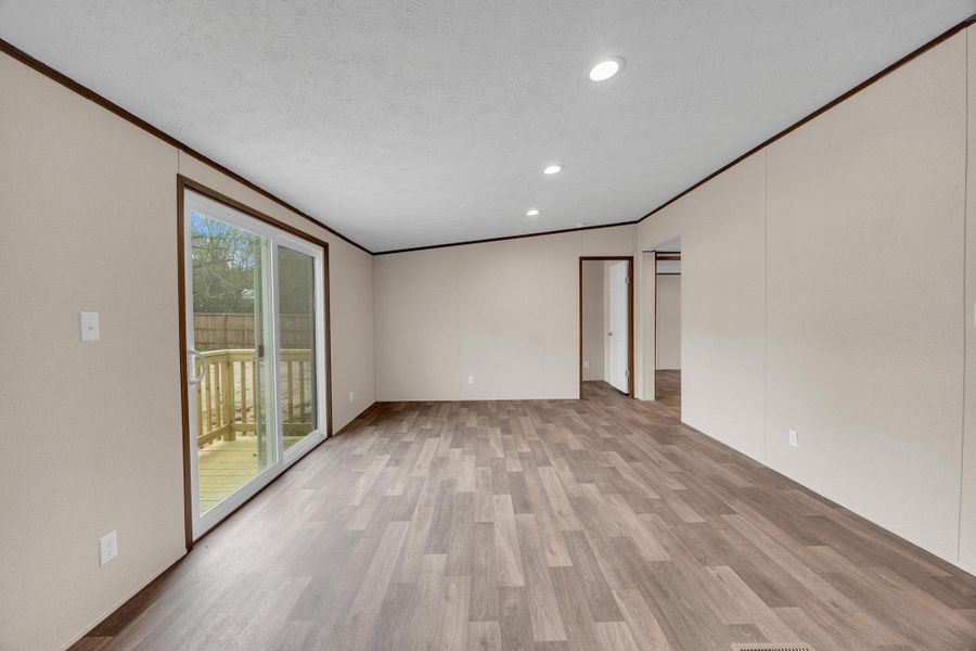 Spare room featuring crown molding, light wood-style flooring, a textured ceiling, and recessed lighting