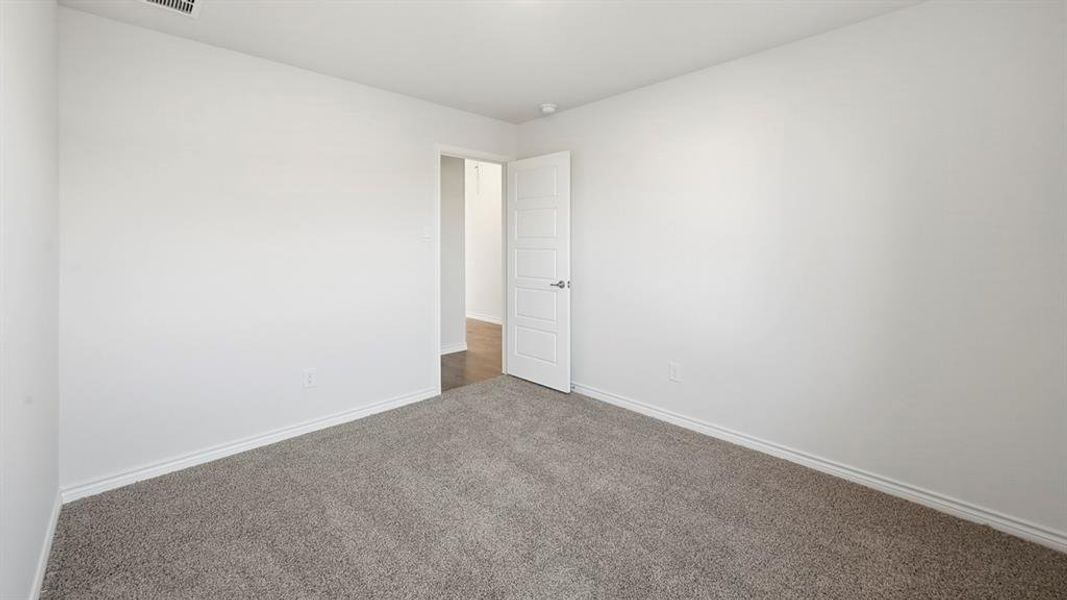 Neutral tone room featuring carpeted flooring and a white paneled door