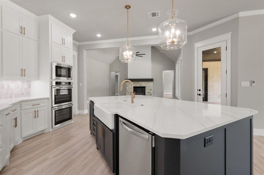 Kitchen island with a farmhouse sink and gold-tone faucet