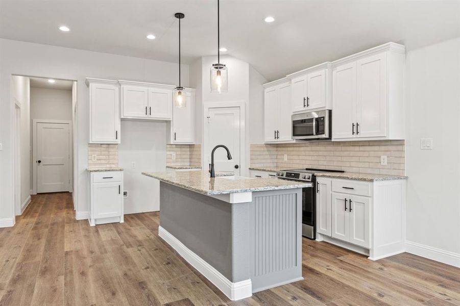Kitchen with white cabinetry, stainless steel appliances, light stone counters, decorative backsplash, and decorative light fixtures