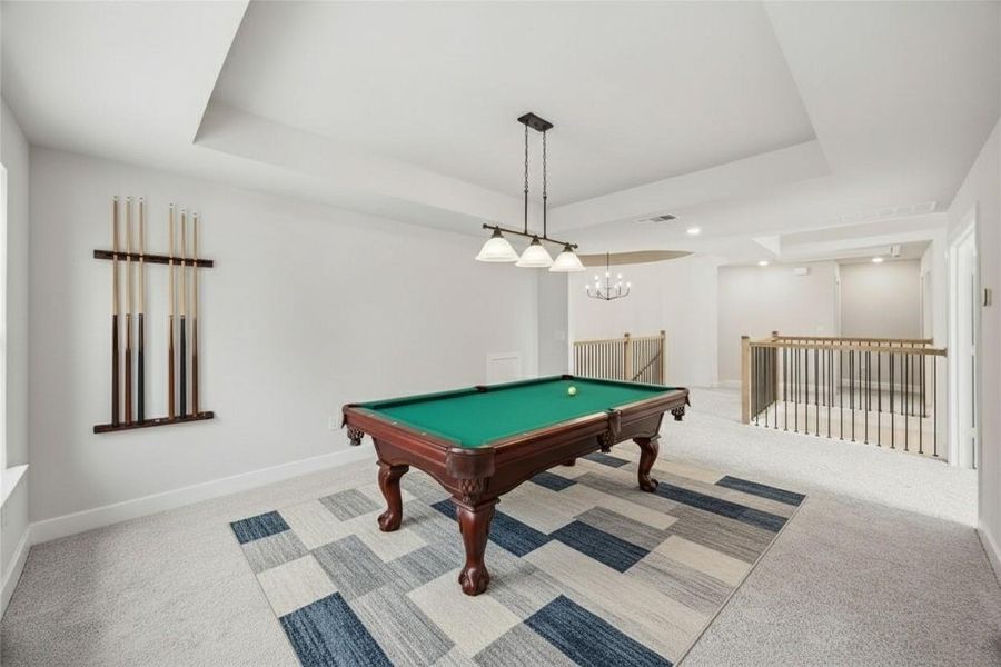 Recreation room with light carpet, a tray ceiling, and pool table