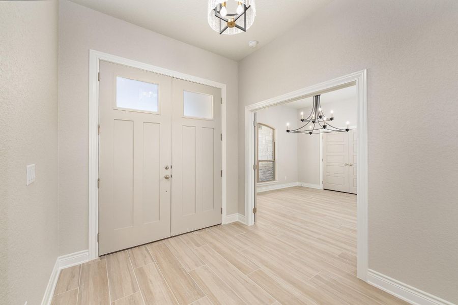 Foyer entrance with a chandelier and wood finish floors Foyer entrance with a chandelier and wood finish floors