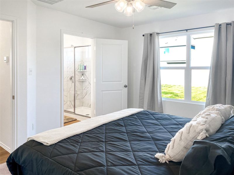Primary bedroom with view to back yard and oversized shower in attached bathroom
