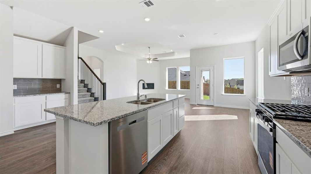 Kitchen featuring tasteful backsplash, white cabinetry, appliances with stainless steel finishes, and recessed lighting Kitchen featuring tasteful backsplash, white cabinetry, appliances with stainless steel finishes, and recessed lighting