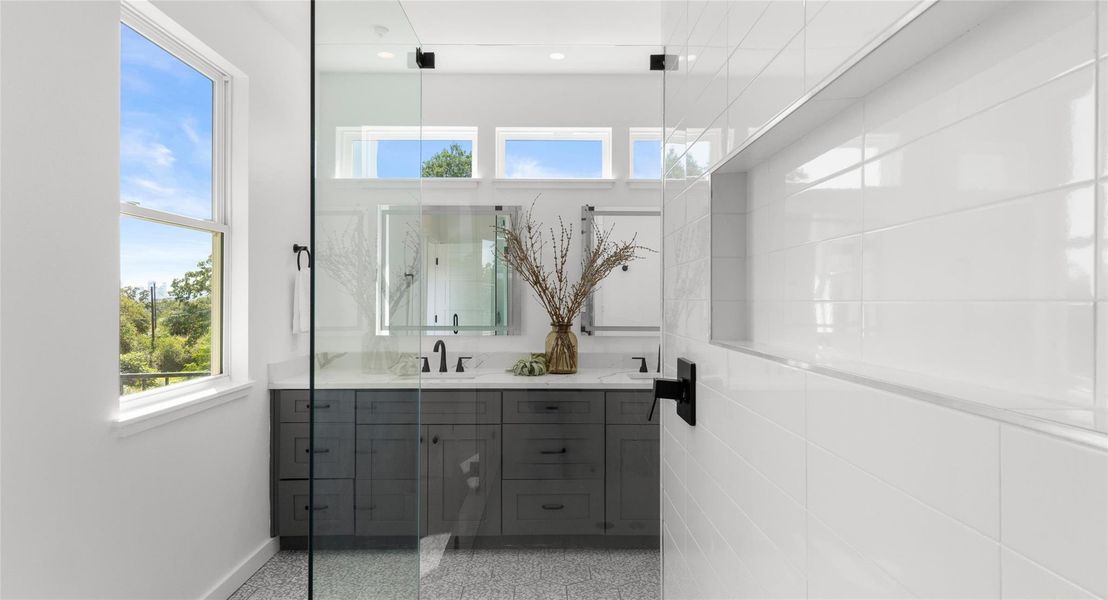 A bright primary bath with a window framing leafy views — a restful way to begin the day. Model No. 105 Shown.