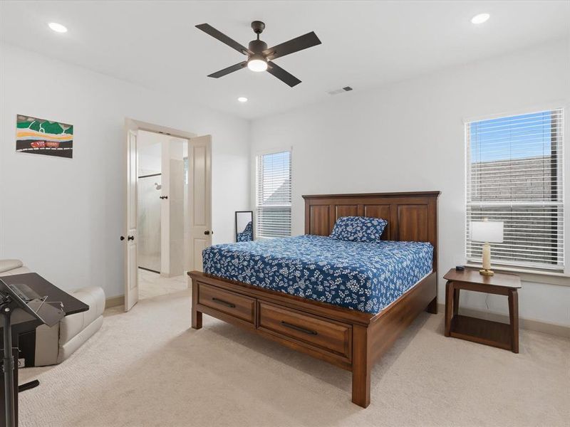Bedroom featuring light-toned carpeting, dual windows with blinds, and recessed lighting