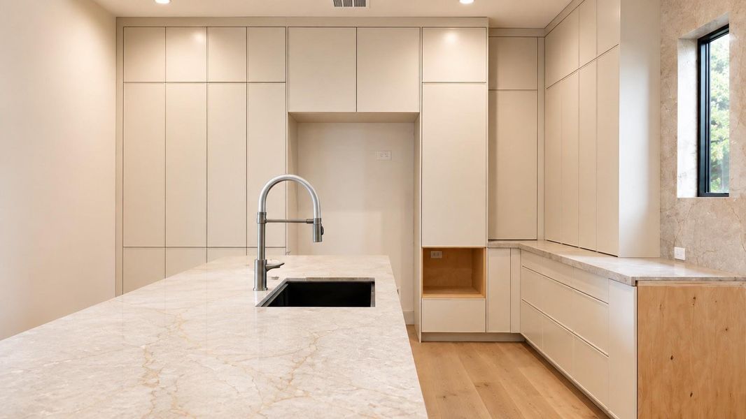 Alternative kitchen view highlighting the expansive Silver Roots marble island, integrated sink, and floor to ceiling custom cabinetry.
