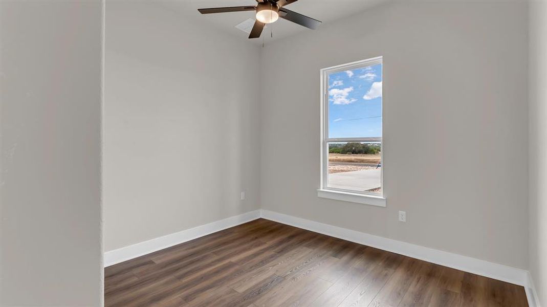 Rich wood-look flooring and a tall window frame tranquil outdoor views in this versatile room. Rich wood-look flooring and a tall window frame tranquil outdoor views in this versatile room.