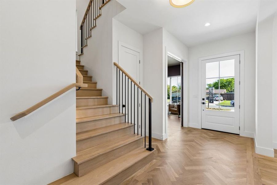 Foyer entrance with stairway and parquet flooring