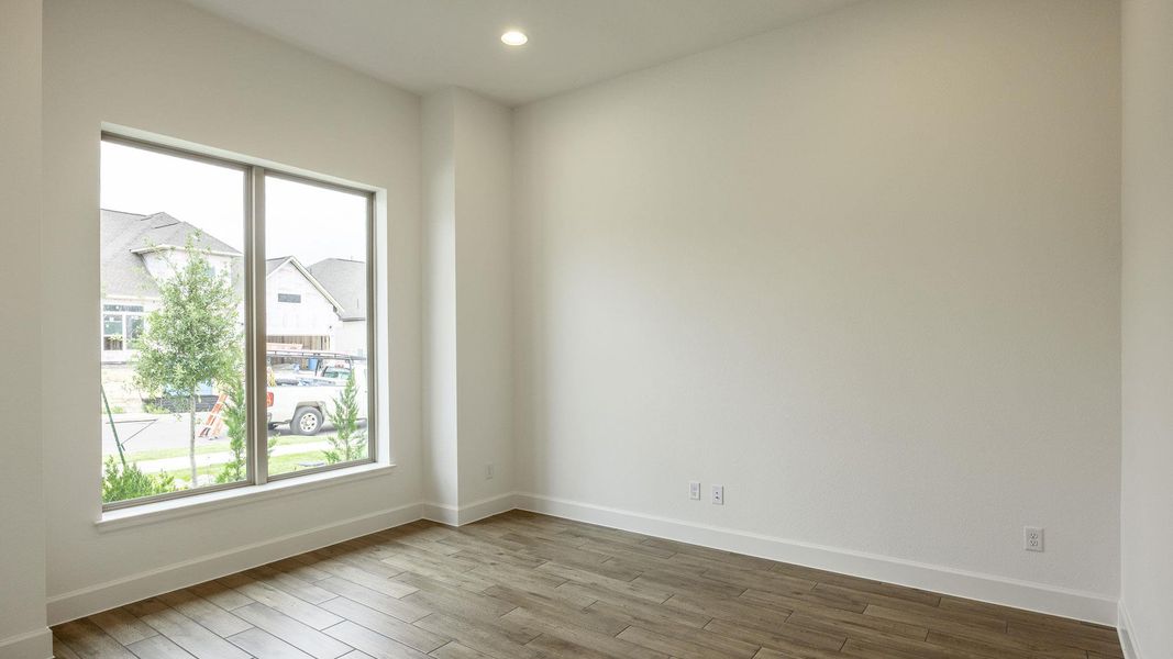 Spare room with baseboards, wood finished floors, and a healthy amount of sunlight Spare room with baseboards, wood finished floors, and a healthy amount of sunlight