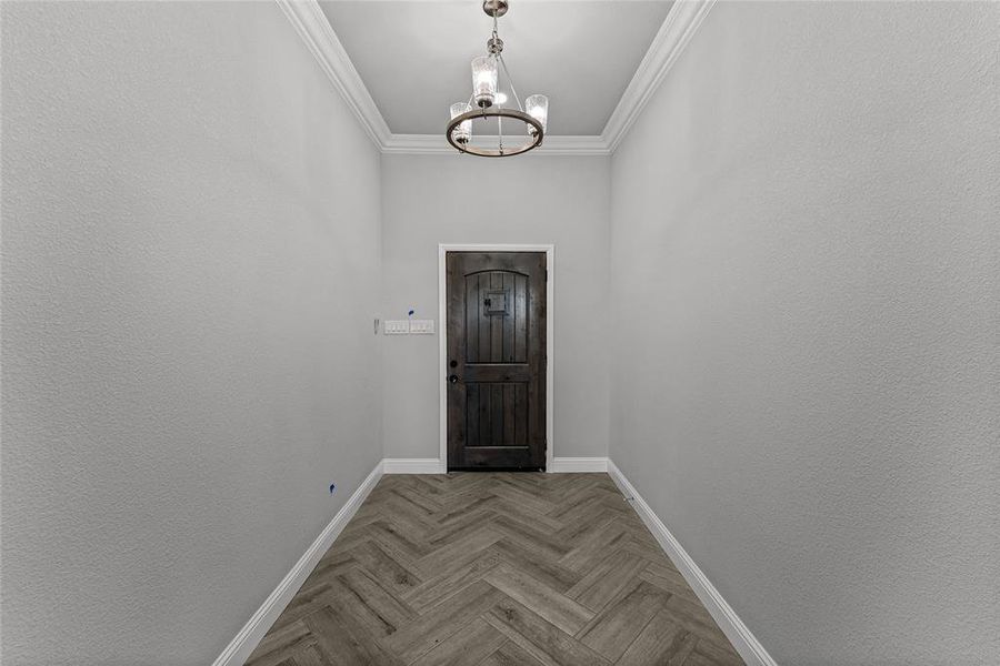Doorway to outside featuring a chandelier and crown molding Doorway to outside featuring a chandelier and crown molding