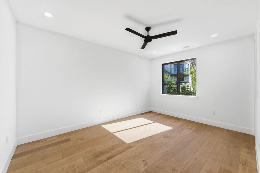 Secondary bedroom featuring light wood-style floors, ceiling fan, and recessed lighting