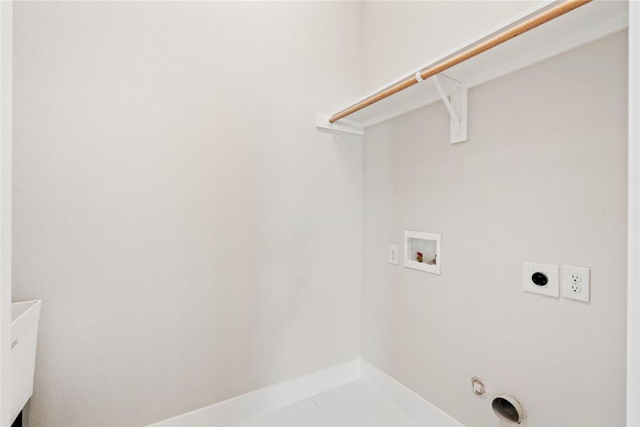 Located off the primary bedroom, this dedicated utility room offers built-in shelving and a sink, keeping laundry routines efficient and discreet.