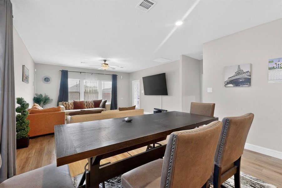 Dining area with light wood finished floors and a ceiling fan Dining area with light wood finished floors and a ceiling fan