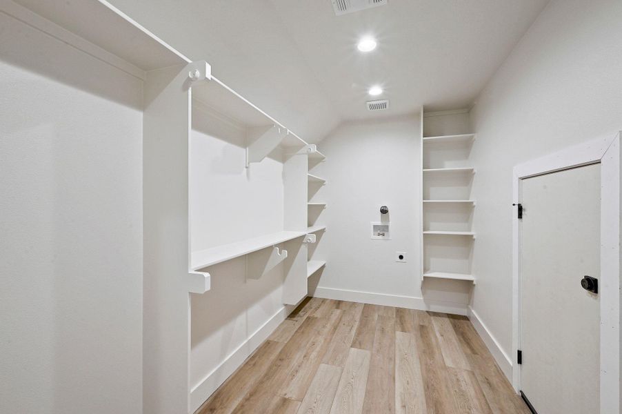 Ample built-in shelving and utility hookups, blending storage and laundry functionality in a bright, open space. Ample built-in shelving and utility hookups, blending storage and laundry functionality in a bright, open space.