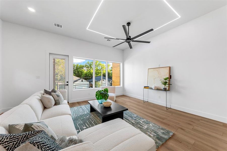 Living area with ceiling fan, wood finished floors, and recessed lighting Living area with ceiling fan, wood finished floors, and recessed lighting