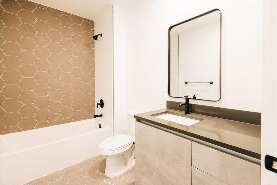 Full bathroom with light tile patterned flooring,  shower combination, and vanity