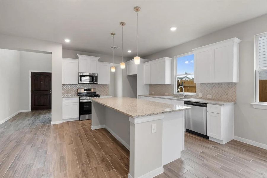 Culinary creations come to life in this kitchen, featuring an inviting island and stainless steel appliances.