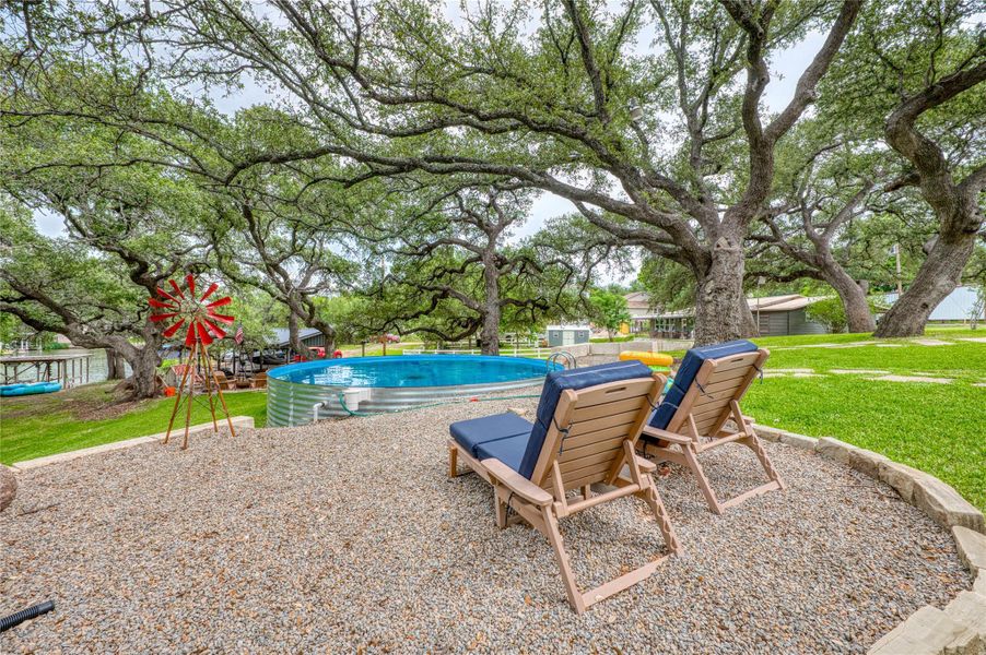 Expansive outdoor area featuring a gravel patio with natural stone edging