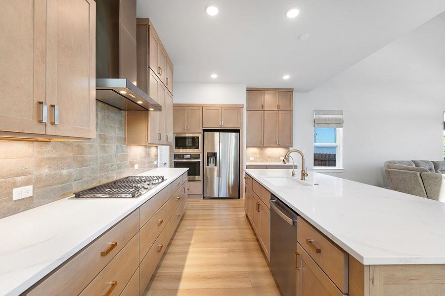Smooth wood cabinetry and sleek stone countertops define this modern, light-filled kitchen space.