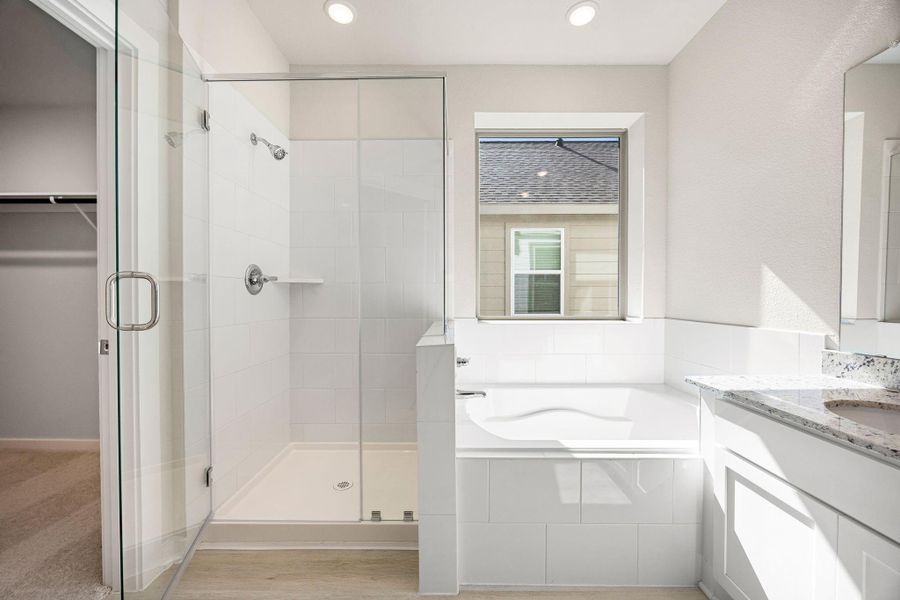 Additionally, the primary bathroom features a spacious frameless glass walk-in shower with a clean white tile surround and a convenient built-in shelf. Adjacent is an elegant soaking tub, perfect for relaxation after a long day, positioned beneath a large window for natural light. Additionally, the primary bathroom features a spacious frameless glass walk-in shower with a clean white tile surround and a convenient built-in shelf. Adjacent is an elegant soaking tub, perfect for relaxation after a long day, positioned beneath a large window for natural light.