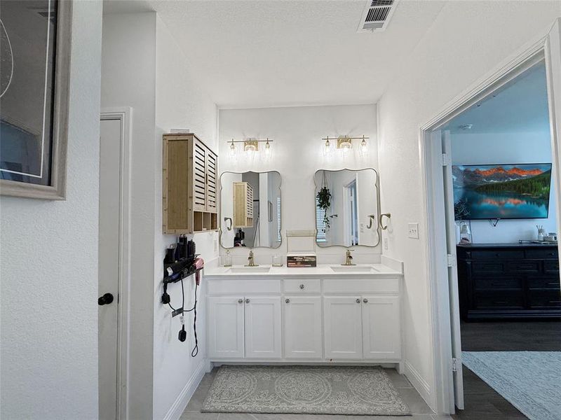 Full bath featuring double vanity and baseboards Full bath featuring double vanity and baseboards