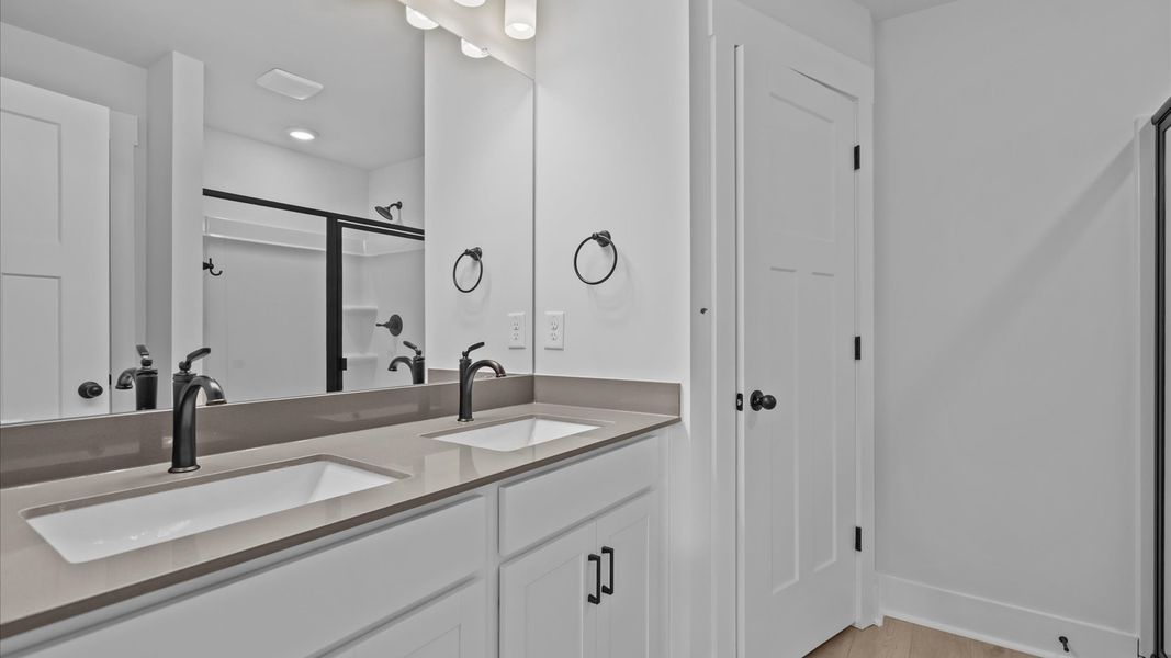 First-rate primary bathroom offering an elegant walk-in shower and dual sinks with superior style First-rate primary bathroom offering an elegant walk-in shower and dual sinks with superior style