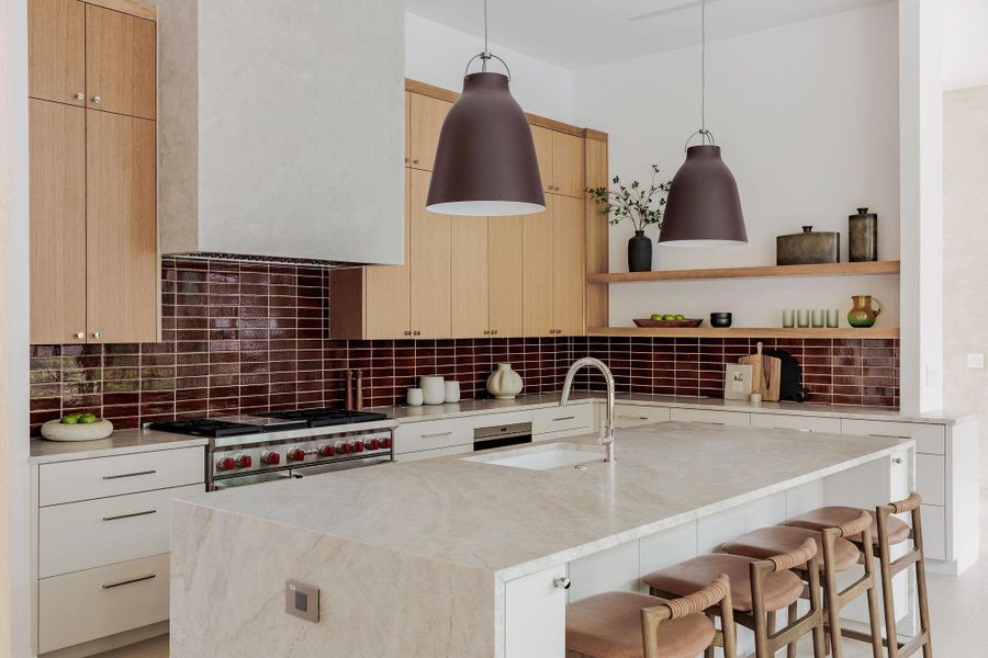 Kitchen featuring range hood, stove, backsplash, a kitchen breakfast bar, and open shelves Kitchen featuring range hood, stove, backsplash, a kitchen breakfast bar, and open shelves