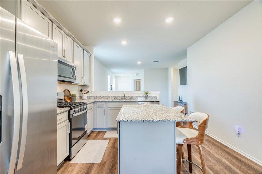 Kitchen features stainless appliances, center island, granite counters, LVP and recessed lighting Kitchen features stainless appliances, center island, granite counters, LVP and recessed lighting