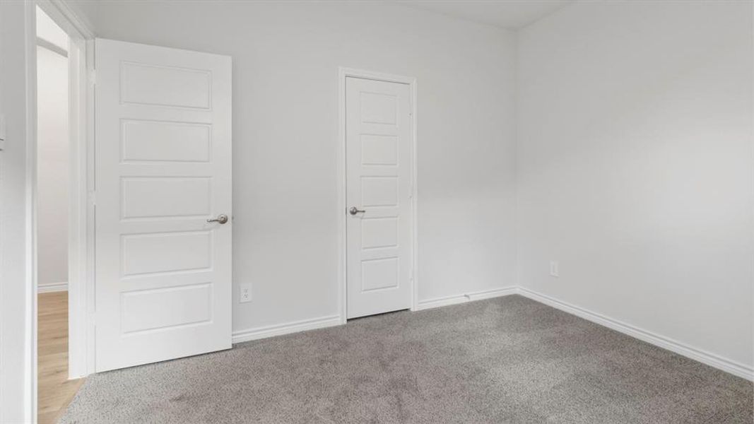 Unfurnished bedroom with carpet and baseboards