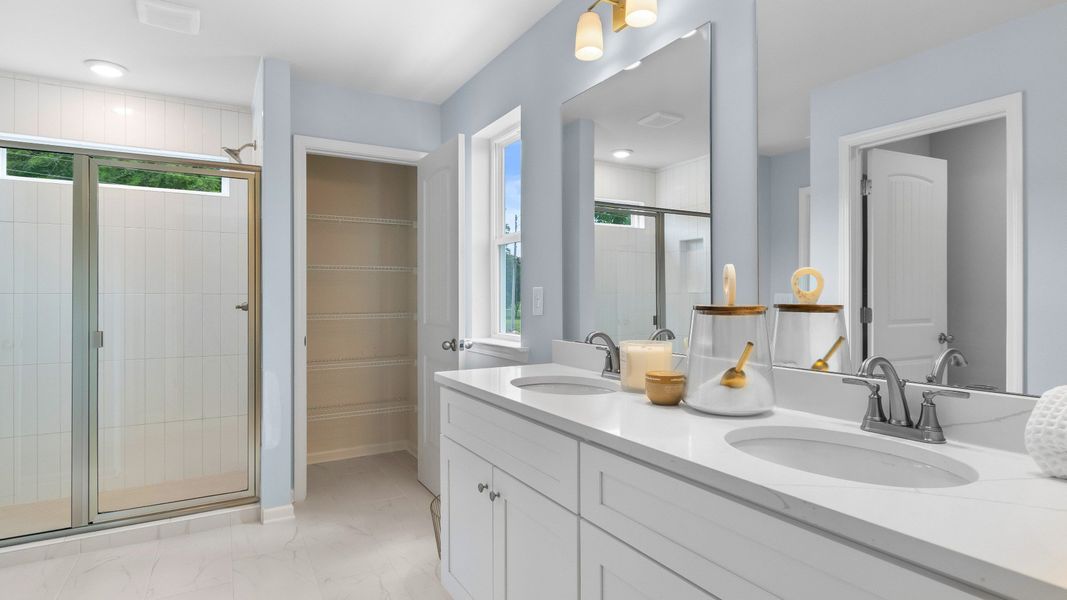 Bathroom with double vanities, quartz countertops, modern fixtures, and large mirror in new construction townhome. Bathroom with double vanities, quartz countertops, modern fixtures, and large mirror in new construction townhome.