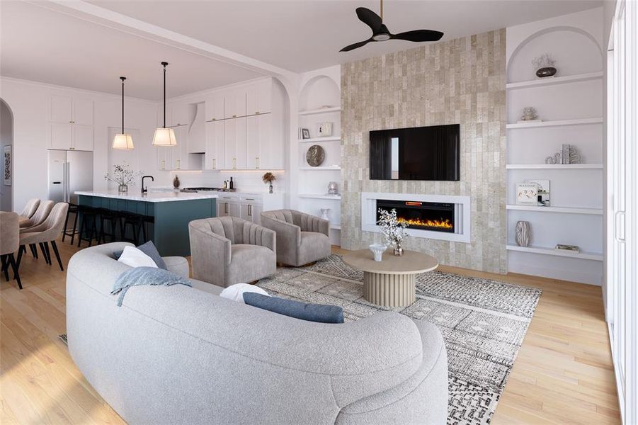 Living room featuring built in features, light wood-style flooring, a tiled fireplace, and arched walkways