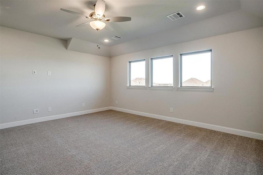 Carpeted empty room featuring ceiling fan