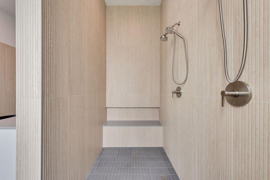 Oversized dual shower with ribbon tile, quartz bench and niche.