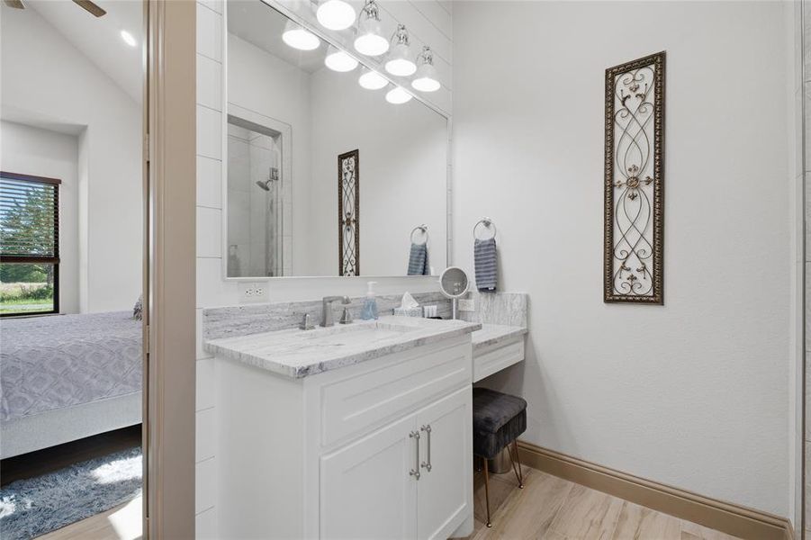 Bathroom vanity featuring a single basin, stone countertop, and built-in vanity area