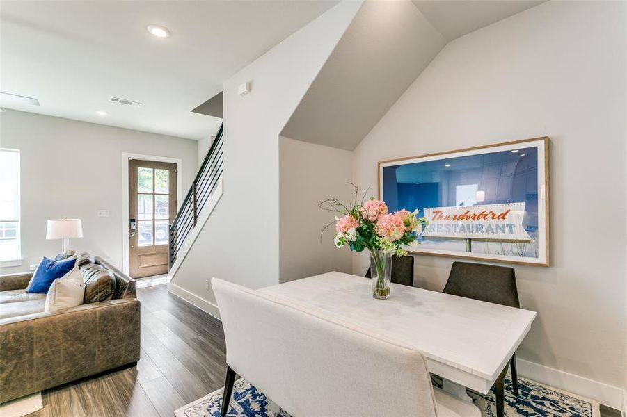 Dining area with hardwood / wood-style flooring and lofted ceiling