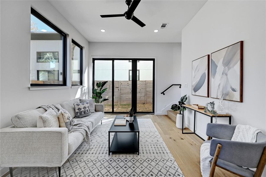 Living area featuring a ceiling fan, light wood-style flooring, and recessed lighting