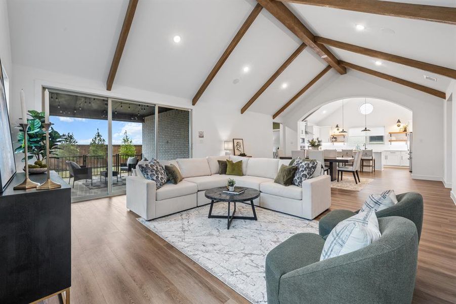 Living room with wood finished floors, high vaulted ceiling, arched walkways, recessed lighting, and beamed ceiling