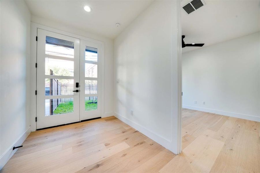 Entryway featuring plenty of natural light, lofted ceiling, and light hardwood / wood-style flooring