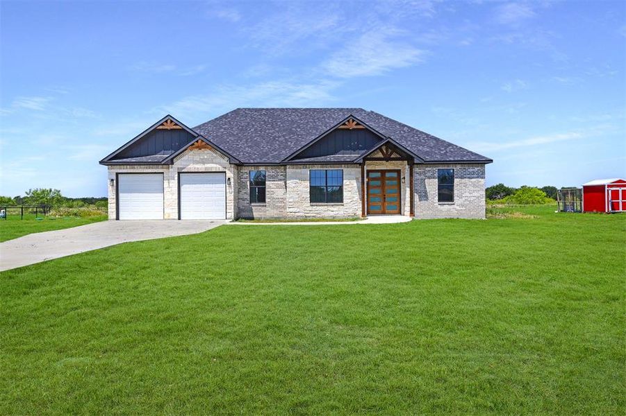 Craftsman house with a garage, a storage unit, and a front yard