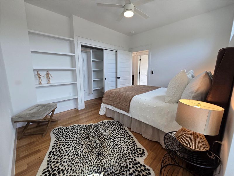 Bedroom featuring wood finished floors, a closet, and a ceiling fan Bedroom featuring wood finished floors, a closet, and a ceiling fan