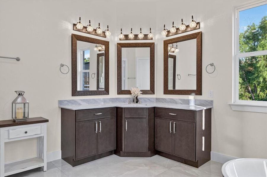 Corner vanity with dual sinks, framed mirrors, and contemporary light fixtures Corner vanity with dual sinks, framed mirrors, and contemporary light fixtures